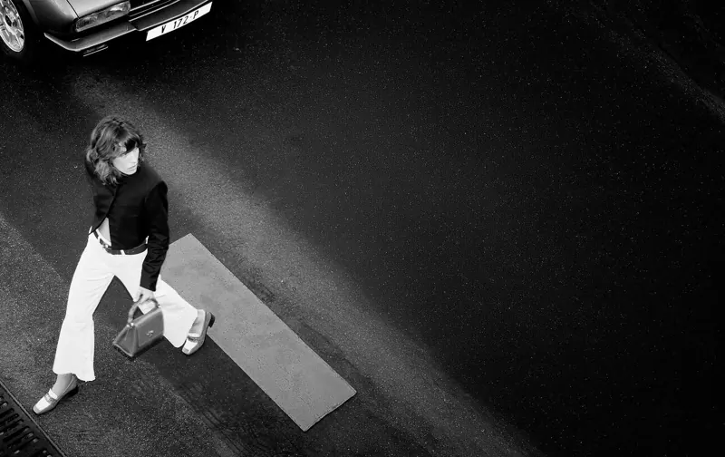 Mujer caminando con un bolso en blanco y negro